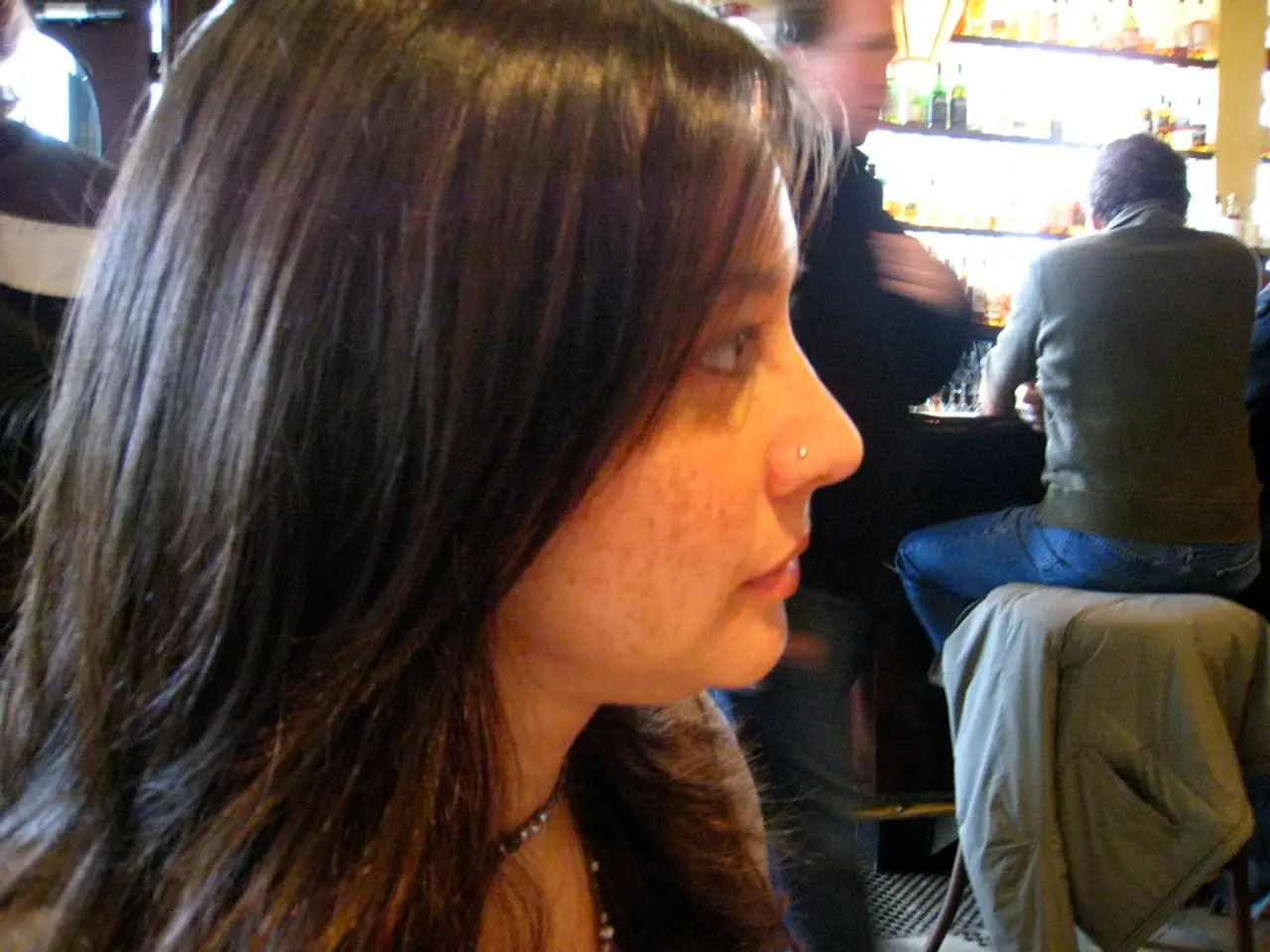 In this image I can see a woman in the front and in the background I can see few men. I can also...