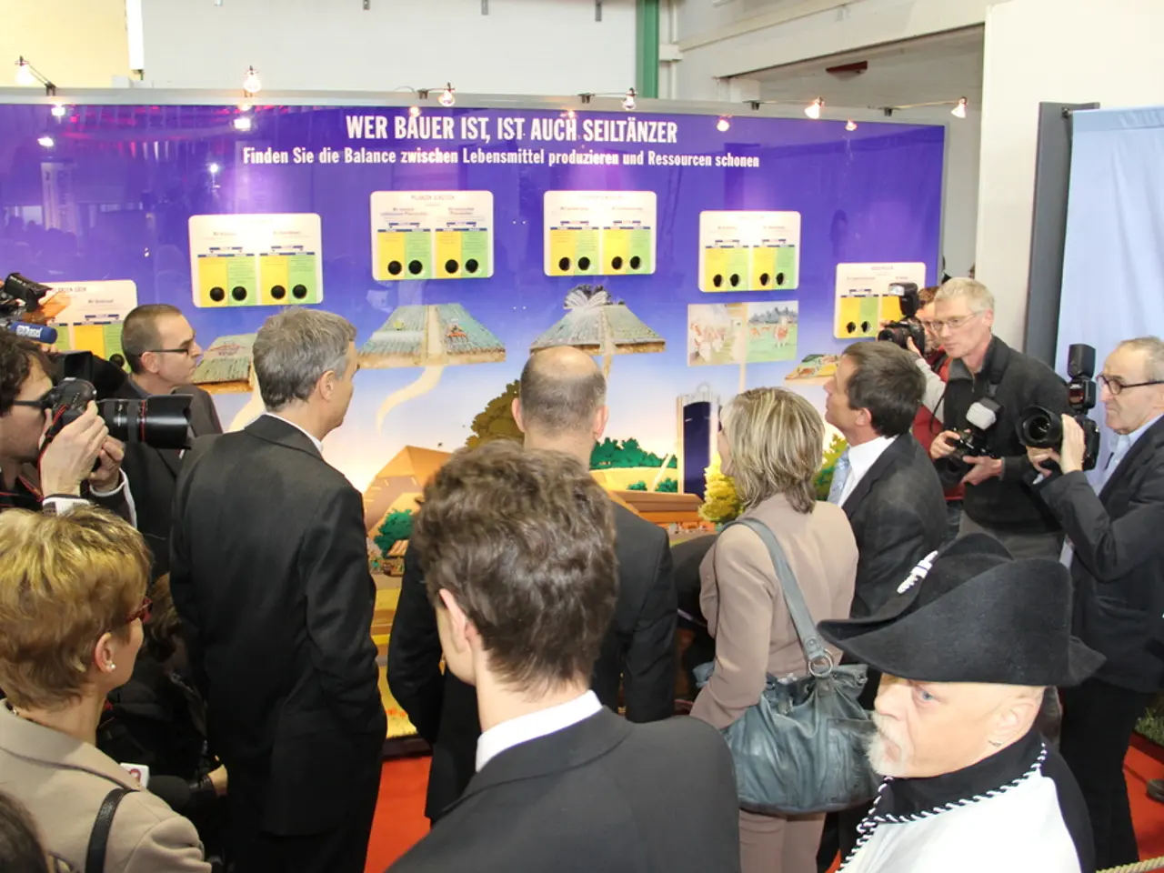 There are group of people standing. Among them few people are holding cameras and clicking...