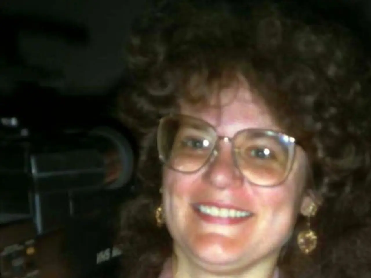 In this image we can see woman holding video camera.