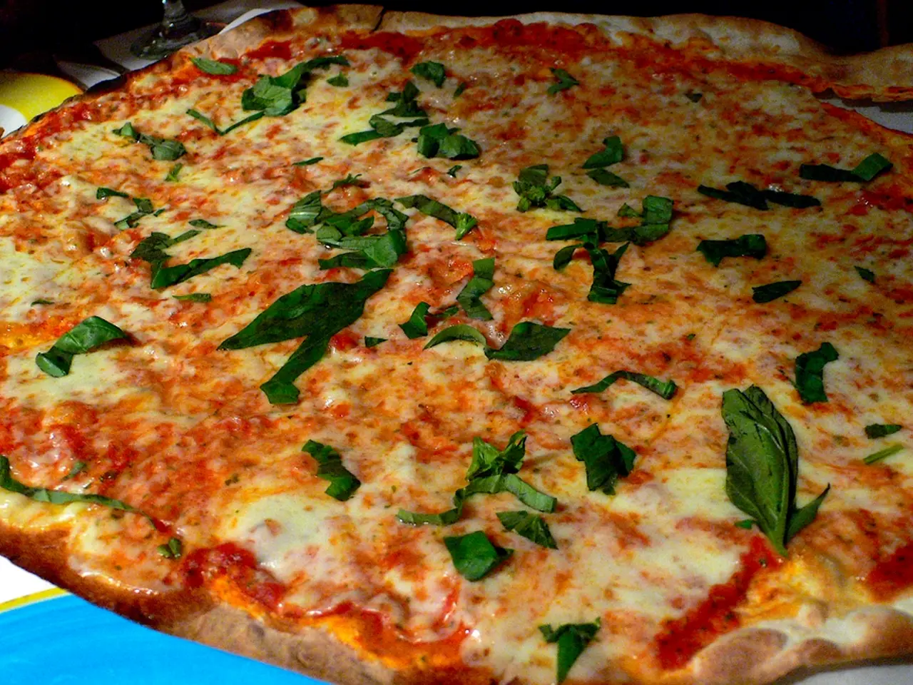 In the picture I can see pizza, on it there are some curry leaves.