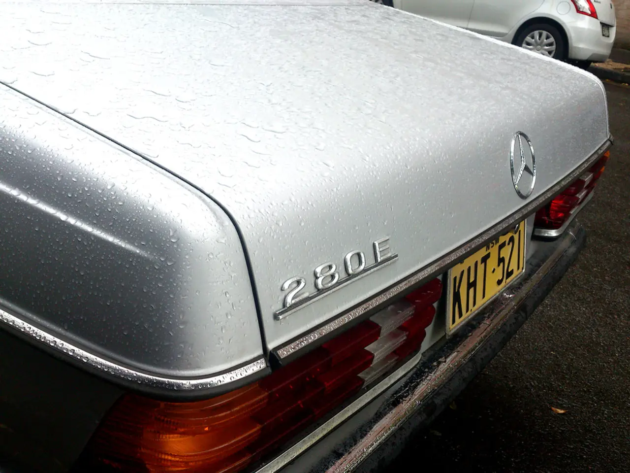 There is a vehicle which has mercedes benz logo on it is on the road and there is another vehicle...