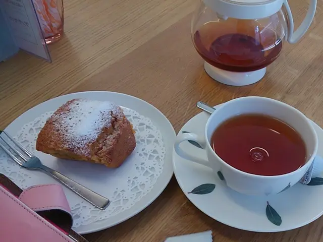 In this image there is a table, on that table there is a wallet, keychain, mug and plates, in one...