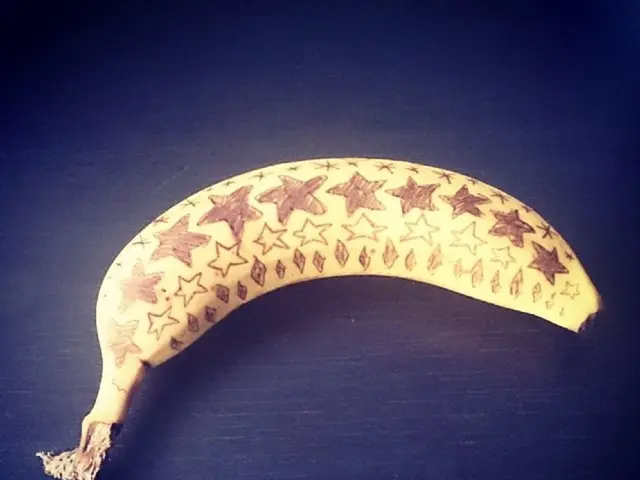 This image consist of a banana which is on the black colour surface.