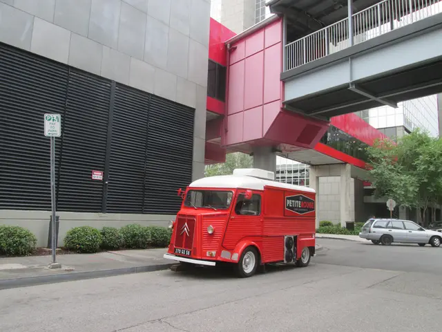 In this picture there is a van in the center of the image and there is a car on the right side of...