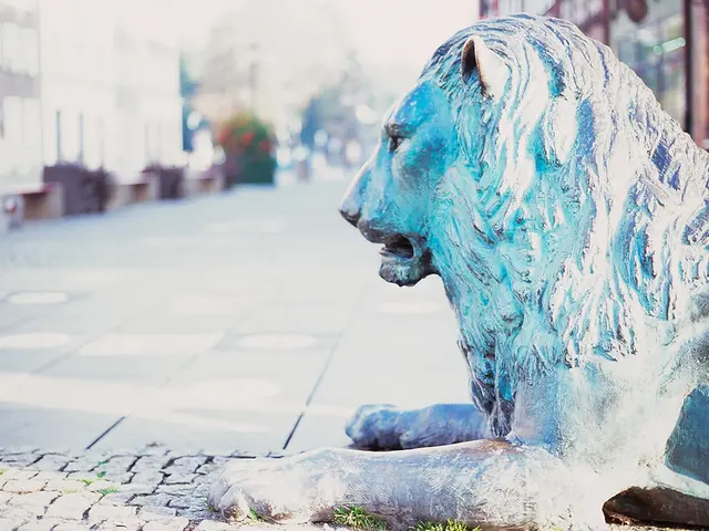 In this picture I can see a lion sculpture in front of the road, side we can see some potted plants...