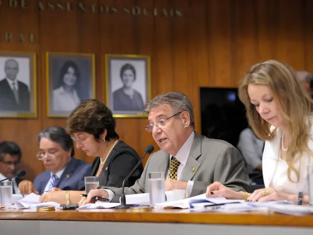 In this image I can see number of people are sitting, I can also see most of them are wearing...