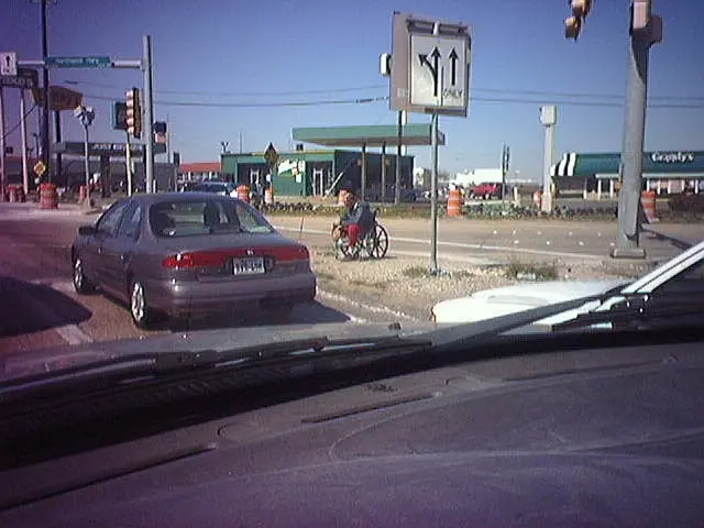 In this image we can see traffic poles, traffic signals, street poles, street lights, buildings and...
